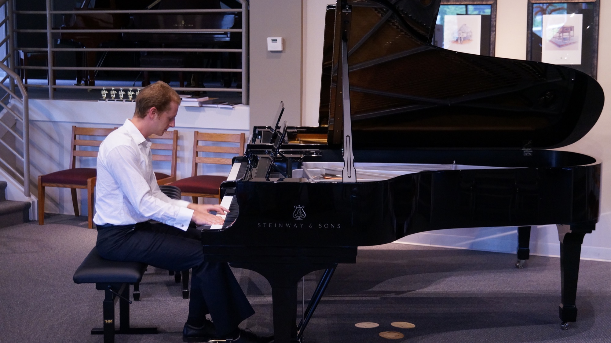Ken, an adult PANC student, playing a grand piano on stage
